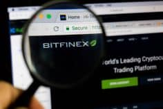 Bitfinex logo on a computer screen with a magnifying glass